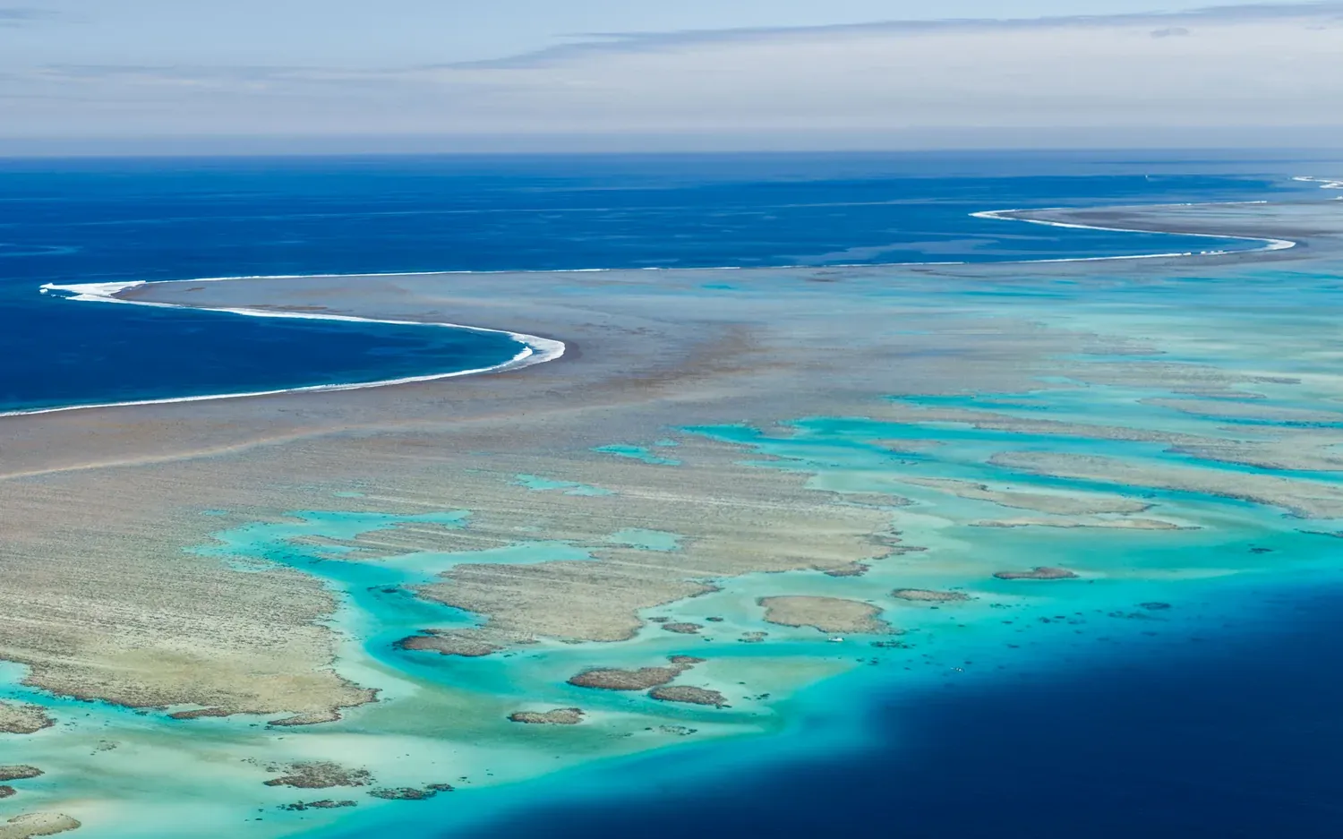Aerial view of the Great Barrier Reef, turquoise lagoon against deep blue water